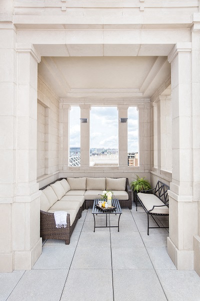 a large white porch with couches and a table
