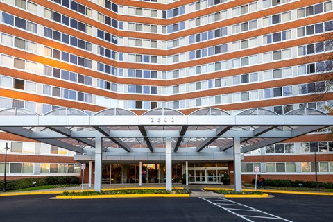a large building with a covered entrance and a parking lot