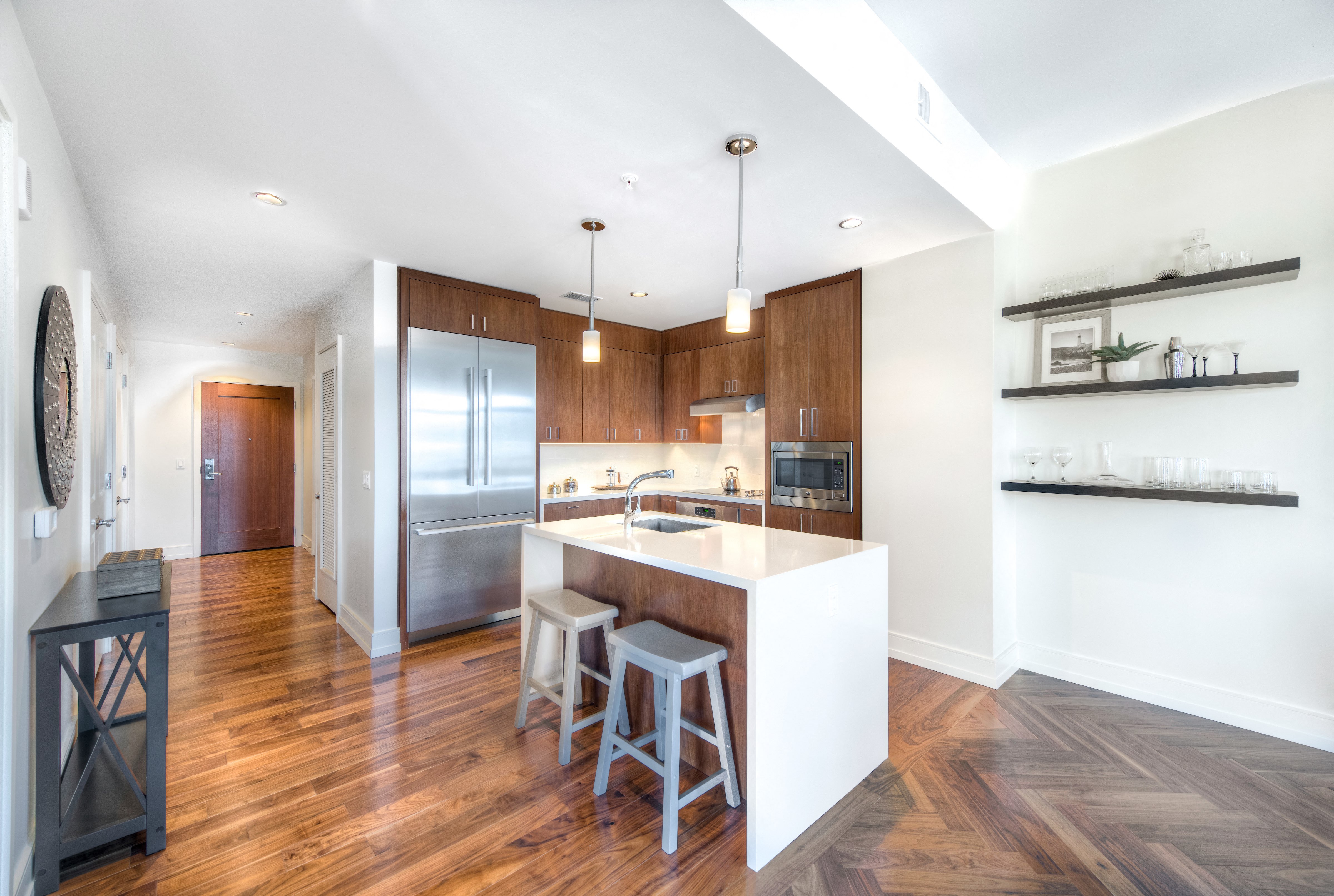 a kitchen with a large island and a stainless steel refrigerator