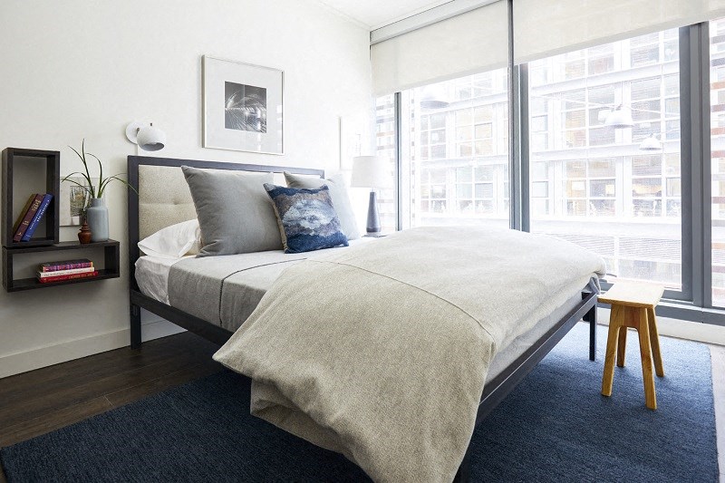 a bedroom with a bed and a large window