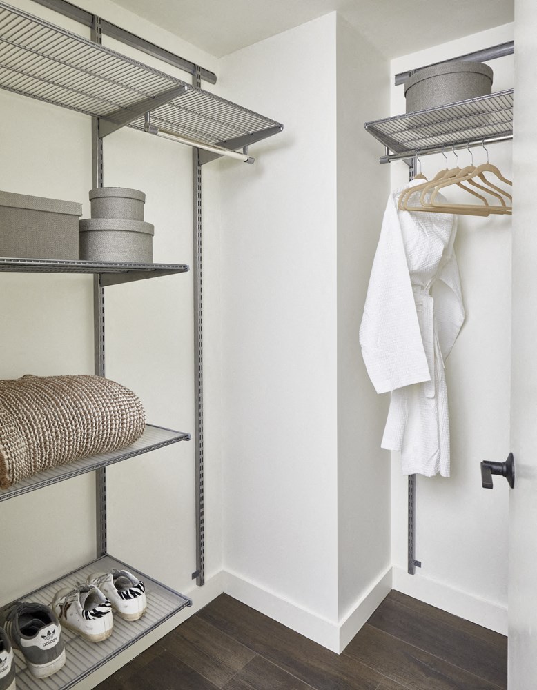 a walk in closet with metal shelving and a closet organizer with shoes and towels