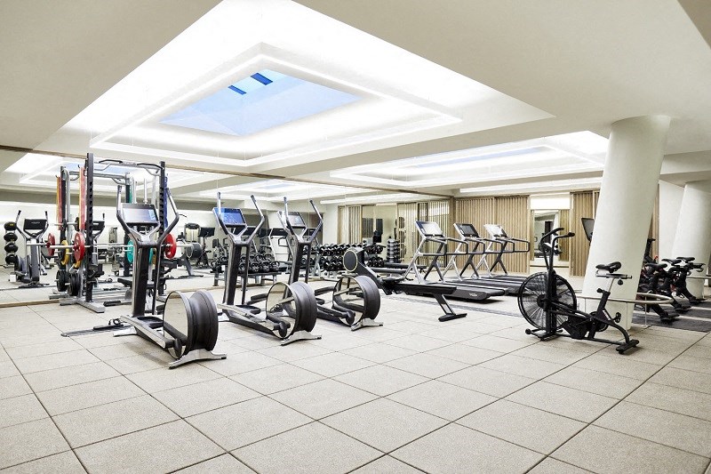 a generously sized workout room with cardio equipment and weights in a building with a large