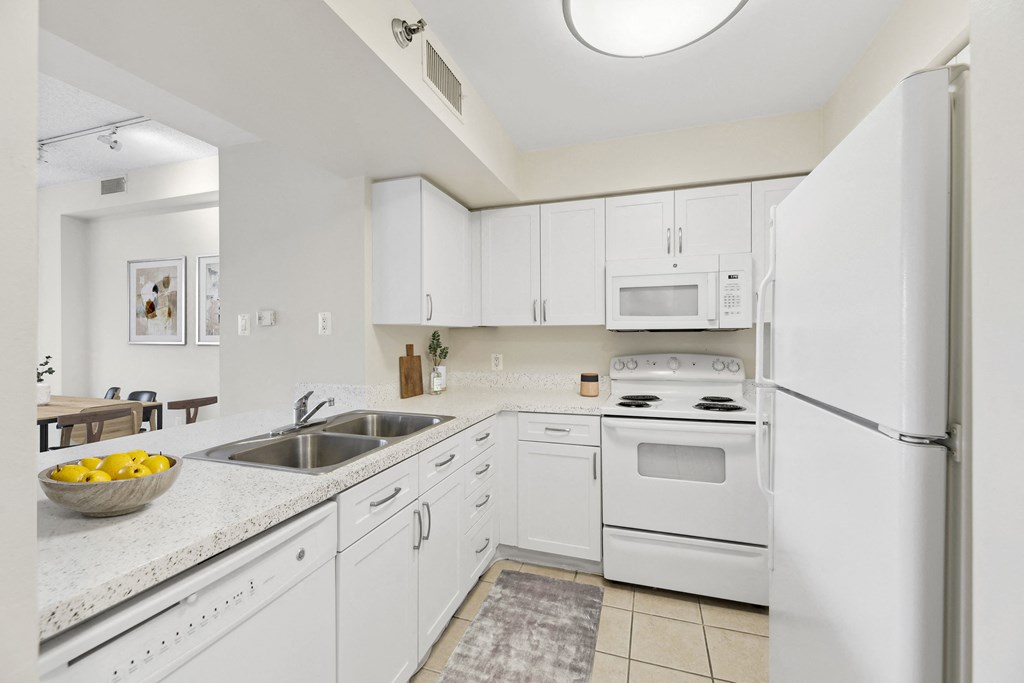 a white kitchen with white appliances and white cabinets
