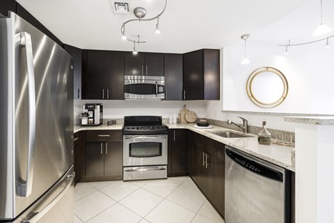 a modern kitchen with stainless steel appliances and black cabinets