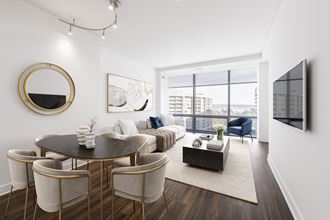 a living room with white walls and hardwood floors and a large window with a city view