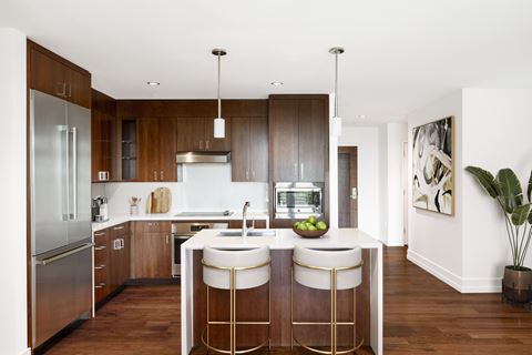 a modern kitchen with wooden cabinets and a white island with three stools