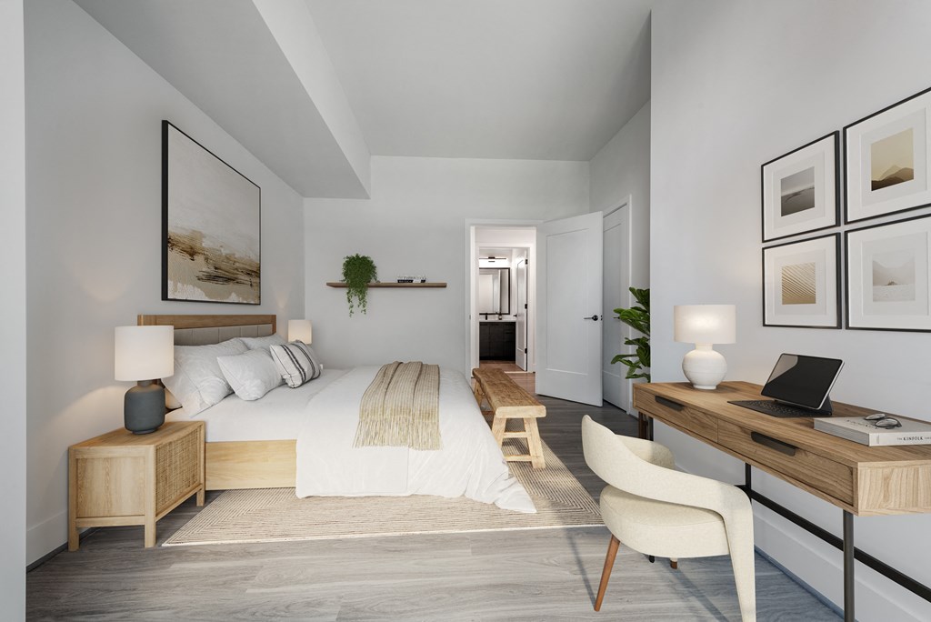 a bedroom with a large bed and a desk with a laptop