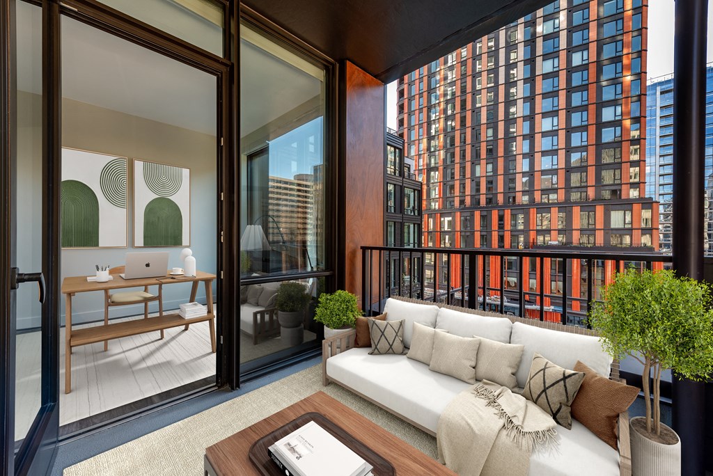 a living area with a couch and a desk in a balcony