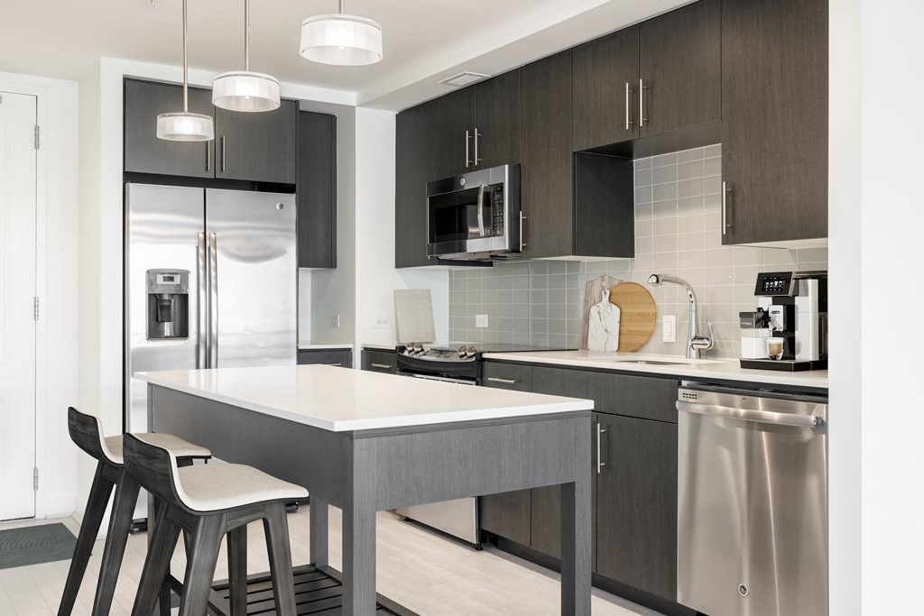 a kitchen with a large island with two stools