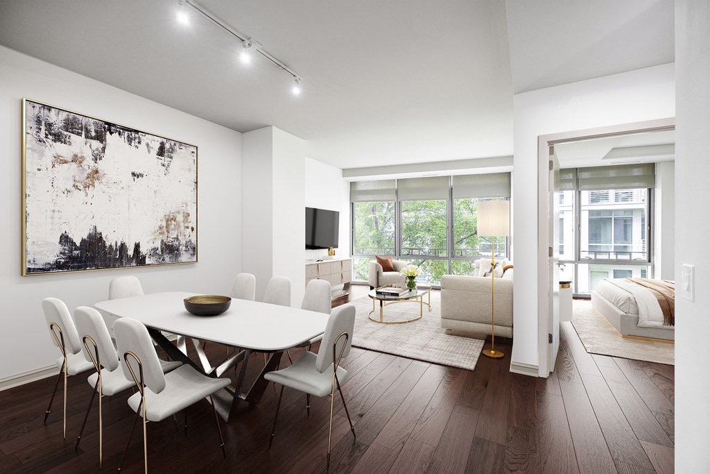 a dining area with a white table and chairs and a tv on the wall