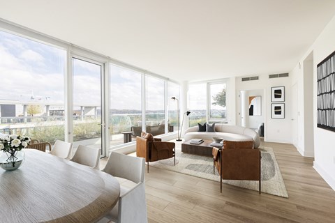 a living room with a large group of windows and a couch and a table