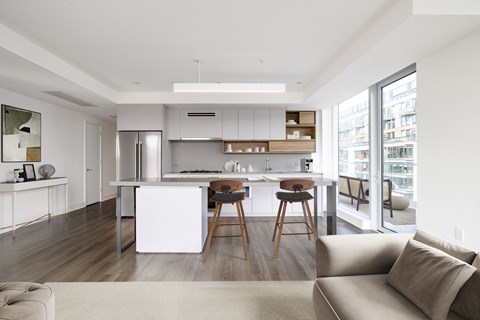a kitchen and living room with an island and bar stools