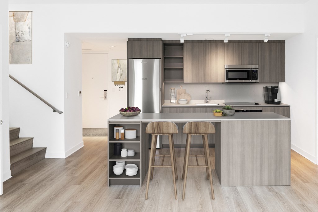 a kitchen with stainless steel appliances and a island with three stools