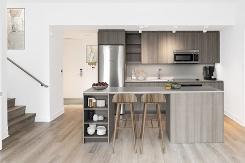 a kitchen with stainless steel appliances and a island with three stools