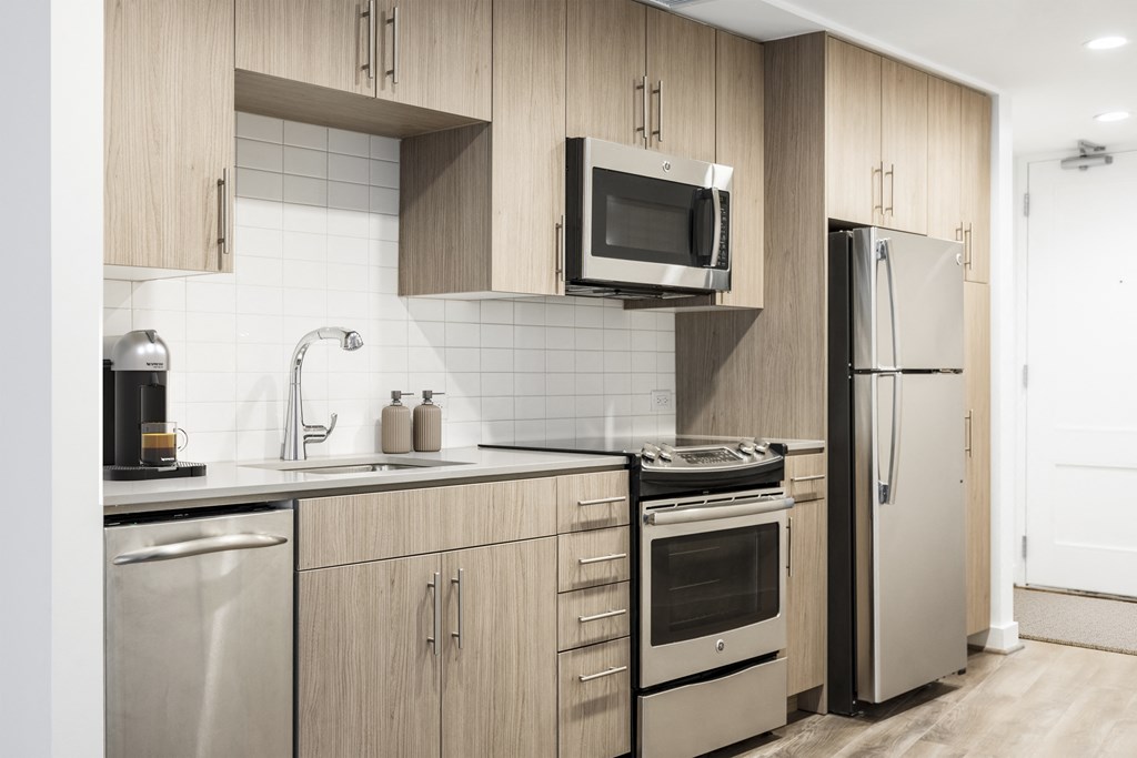 a kitchen with wooden cabinets and stainless steel appliances