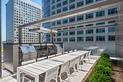 A modern outdoor dining area with white chairs and tables.