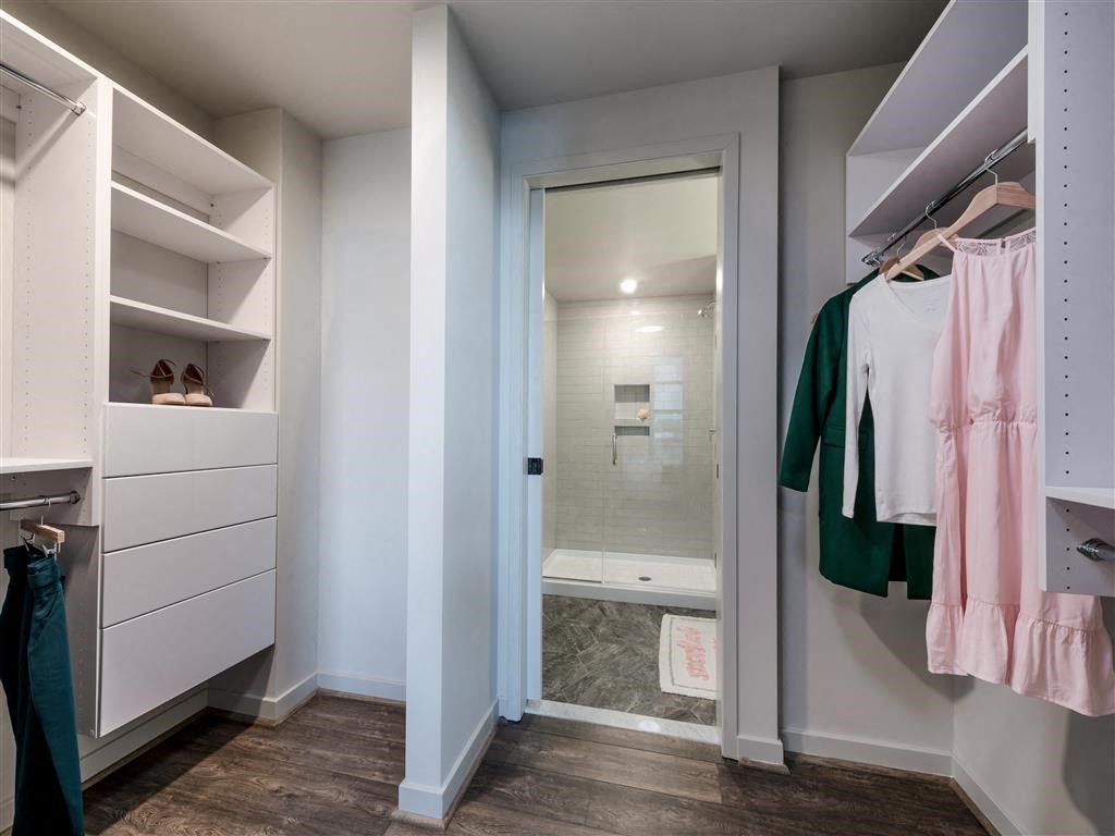 a dressing room with a closet and a shower
