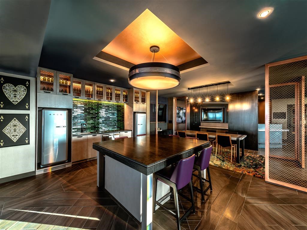 a kitchen with a long counter and chairs