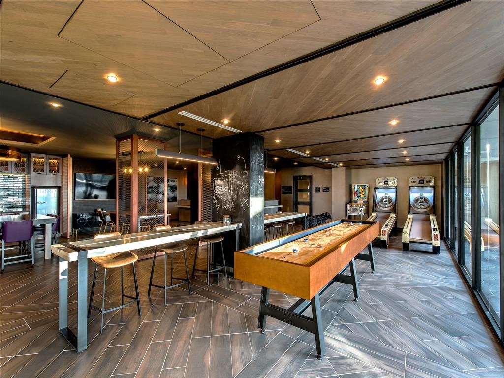 a recreation room with a shuffleboard table and a foosball table