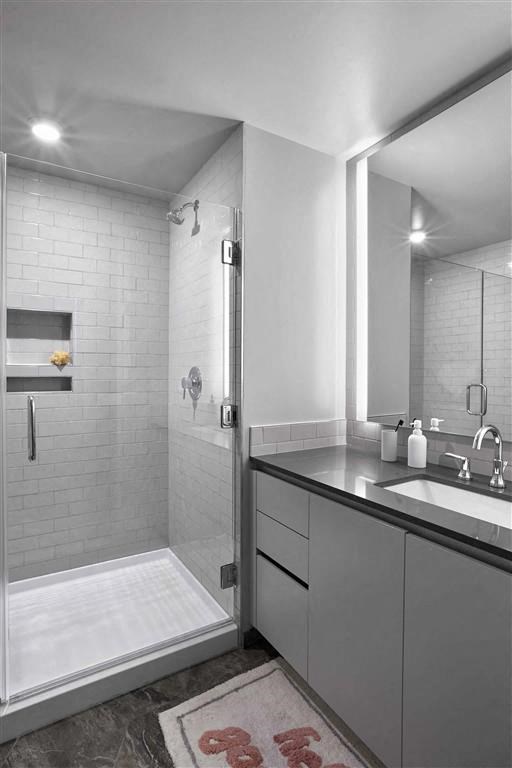 a bathroom with a shower and a sink and a mirror