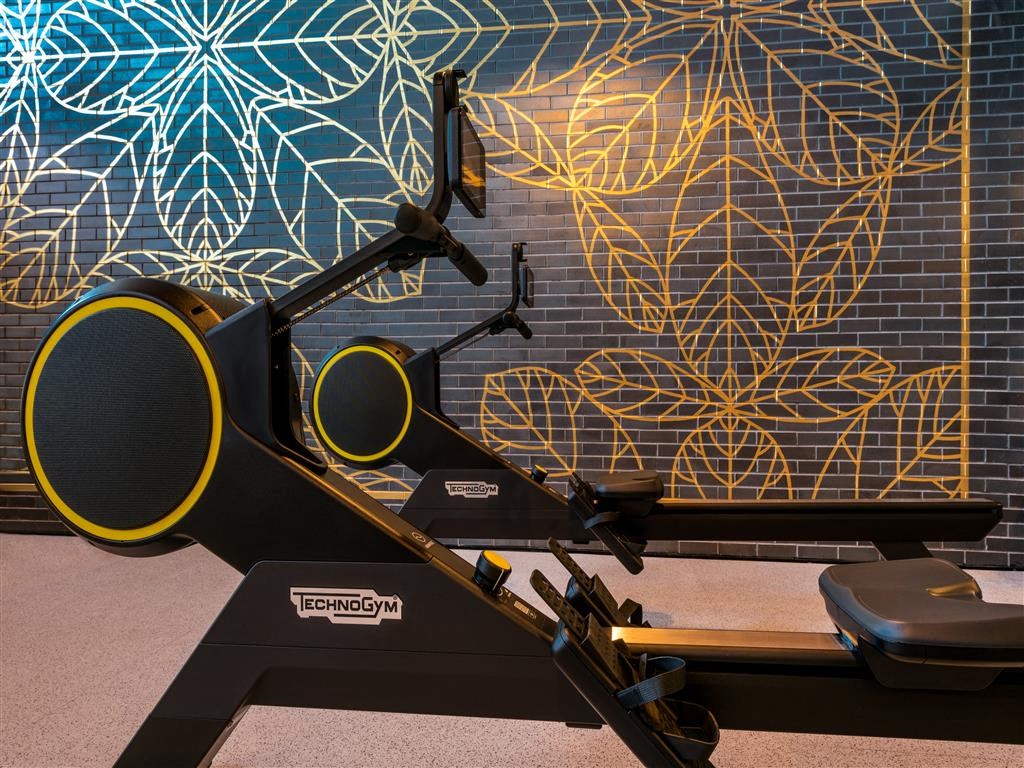 a treadmill in front of a mural of leaves