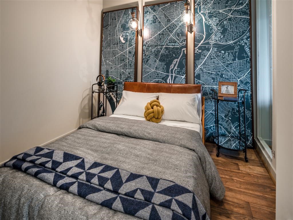 a bedroom with a bed and a blue and white bedspread and a large window