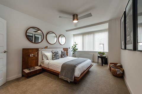 a bedroom with a bed and two mirrors on the wall