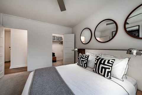 a bedroom with a bed and mirrors on the wall