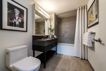 Spa-inspired baths with porcelain tile tub and shower, porcelain tile floor, custom vanity with quartz countertop, and high-end fixtures