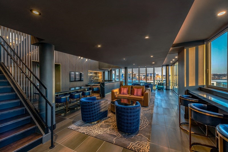 a living room with couches and chairs and a staircase