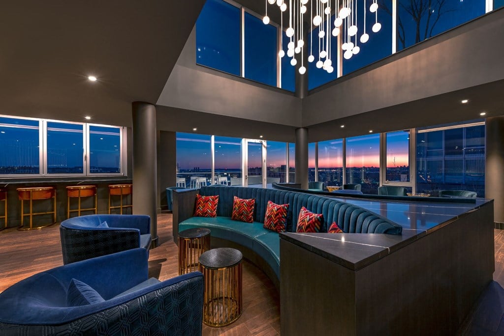 a lounge area with blue furniture and a window view of the city