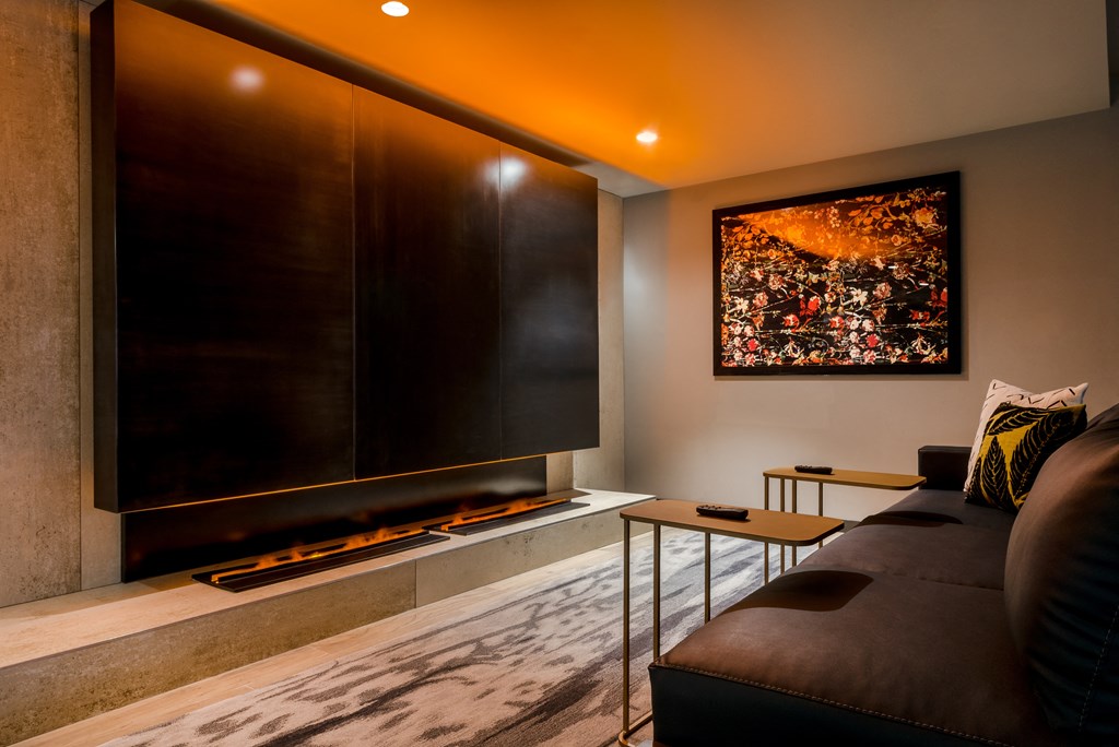 a living room with a large screen tv on the wall and a couch in front of it