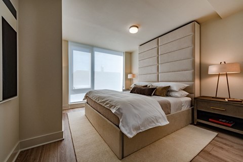 the master bedroom has a large bed and a large window