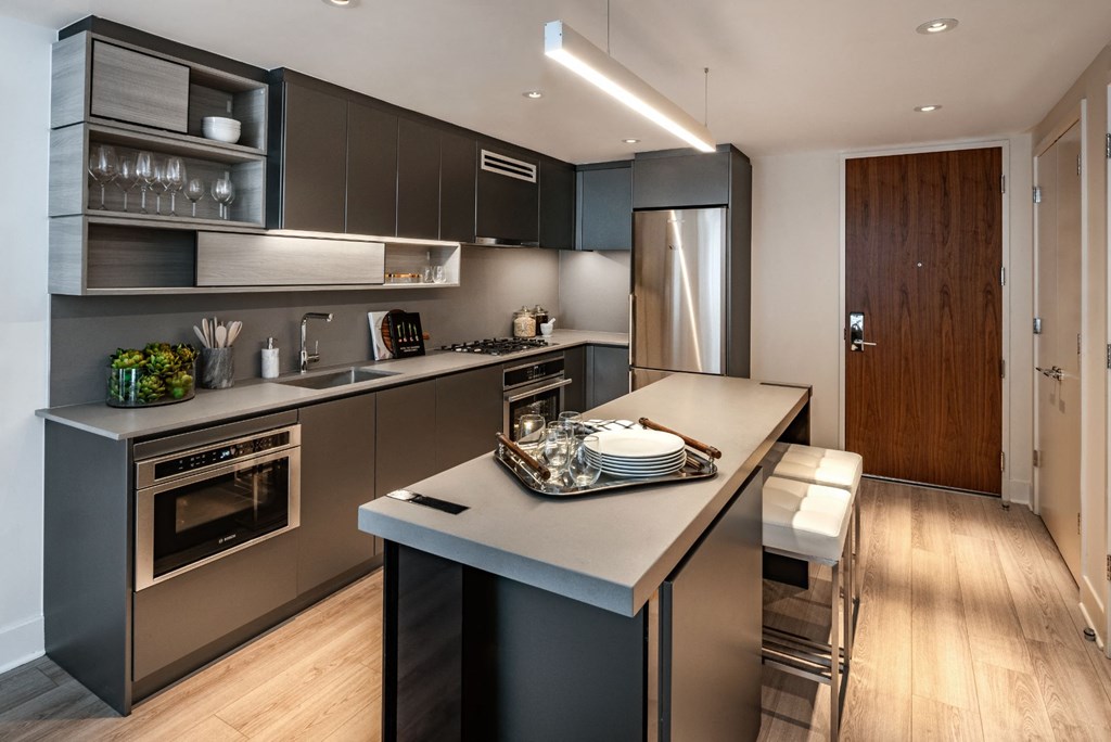 a kitchen with a large island and stainless steel appliances