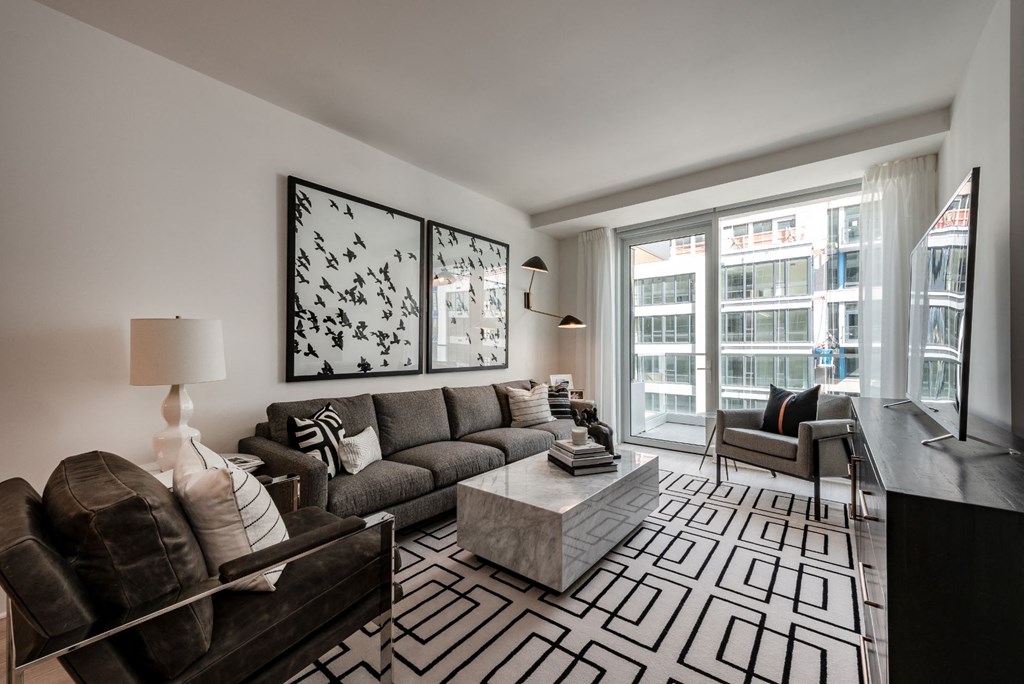 a living room with a couch and a coffee table and a large window