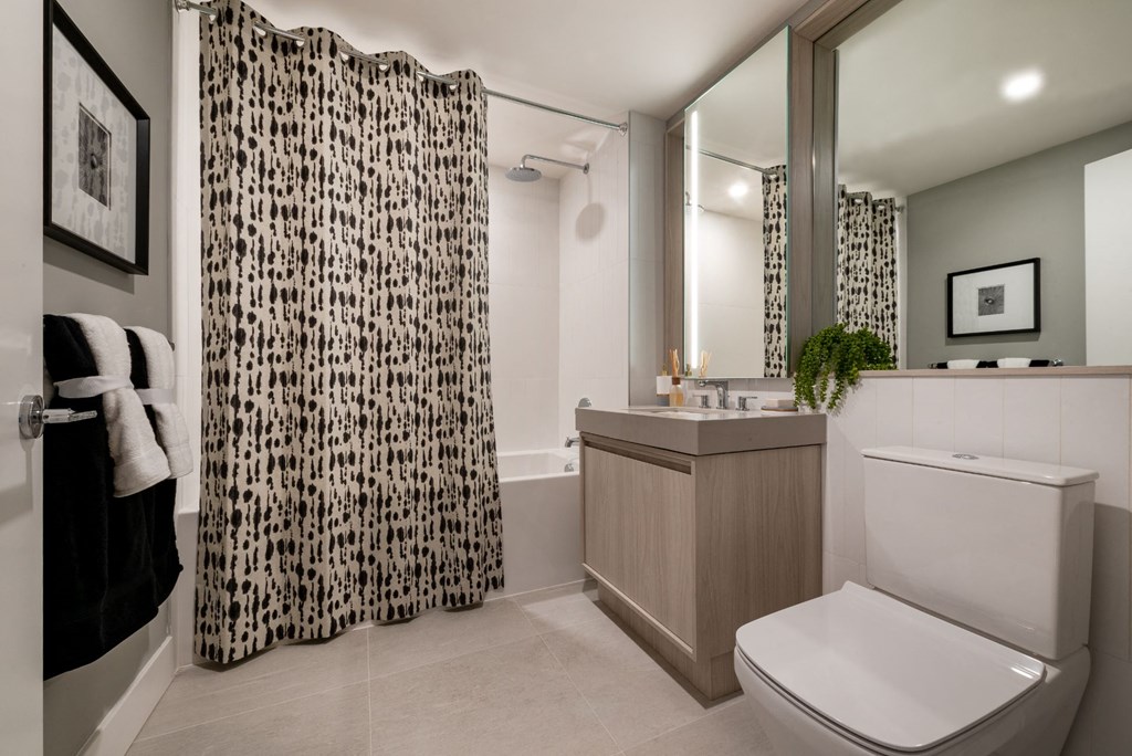 a bathroom with a shower and a toilet and a sink