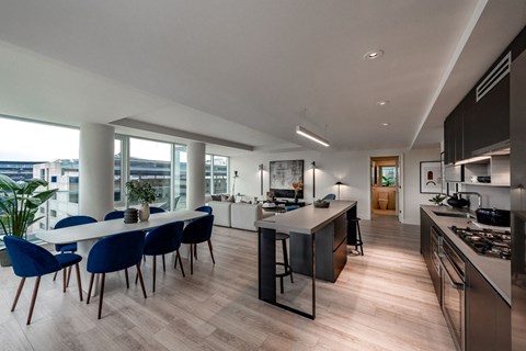 an open kitchen and dining area with a large table and chairs and a large window