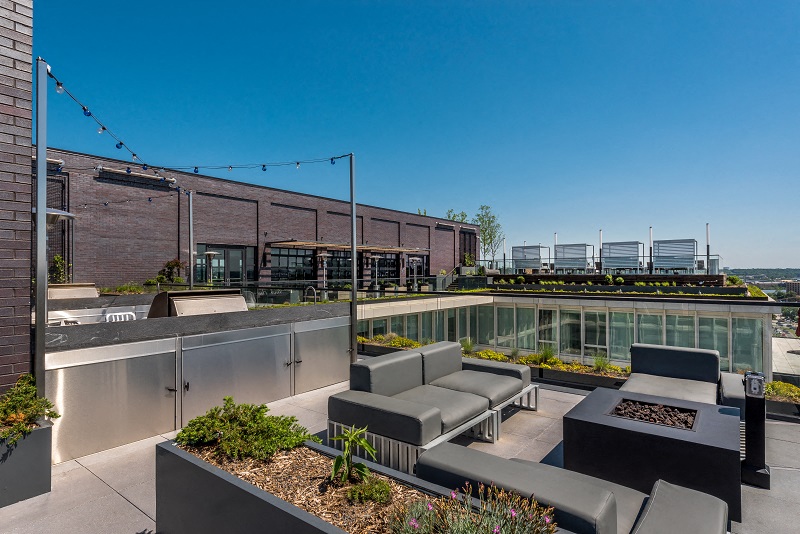 a rooftop patio with furniture and a building in the background