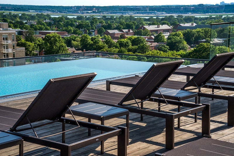 a group of lounge chairs on a deck next to a pool