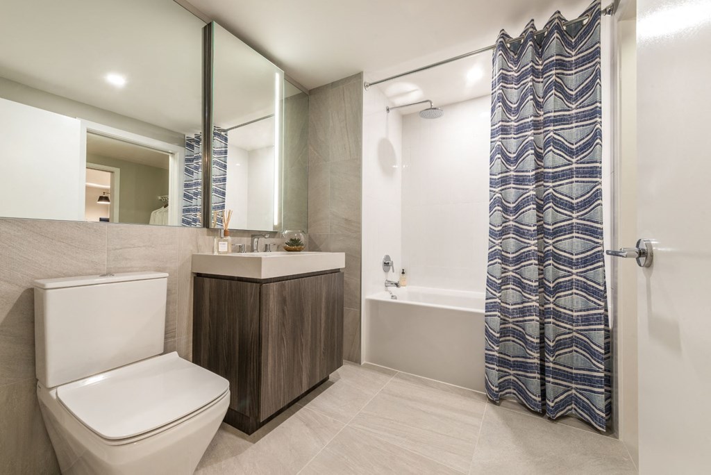 a bathroom with a toilet and a shower and a sink