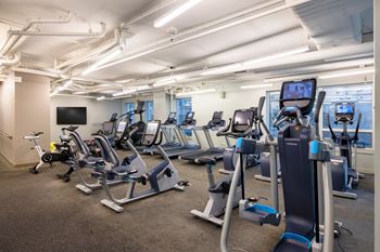 a gym with various cardio machines and weights