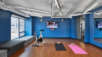 a workout room with yoga equipment and a tv on the wall