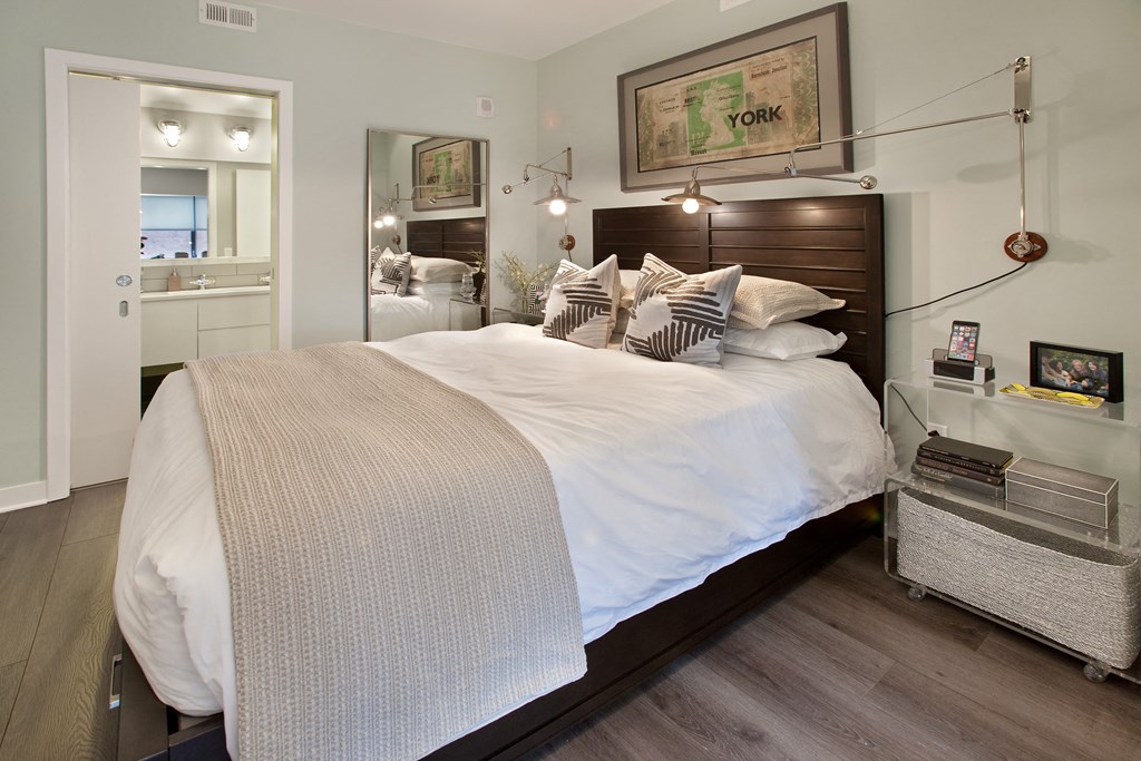 a bedroom with a bed with white sheets and pillows