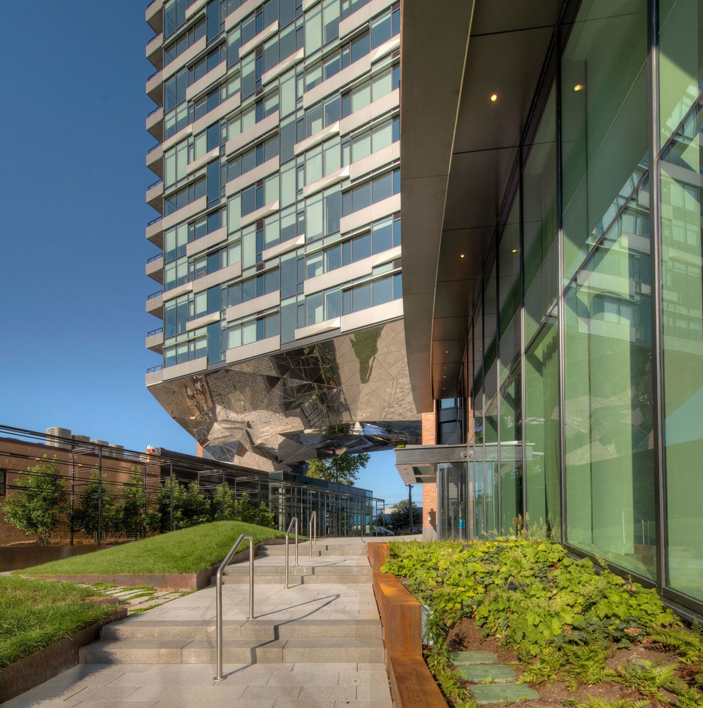a view of the side of a tall building with a glass facade and a staircase
