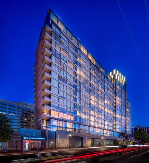 a tall building at night with lights on the side of it