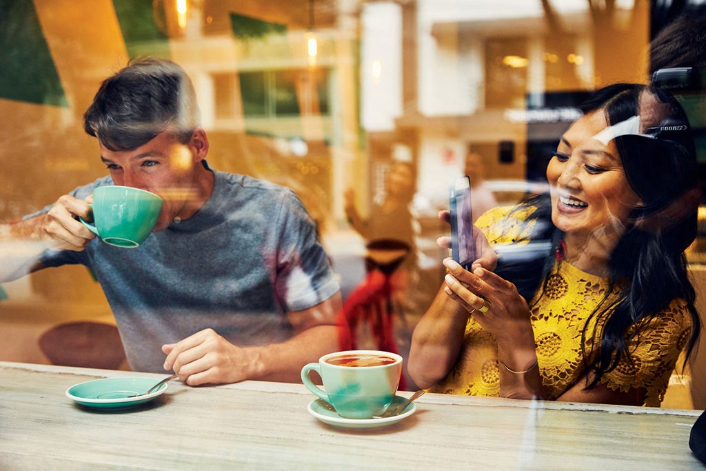 a man and a woman sitting at a table drinking coffee
