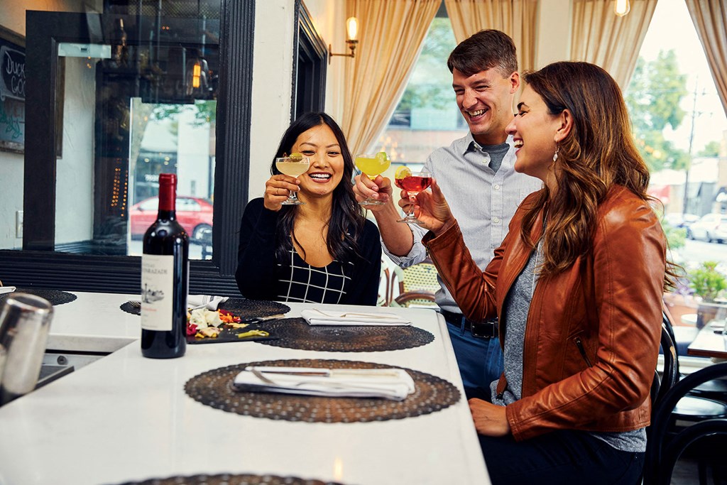 a group of people sitting at a table drinking wine