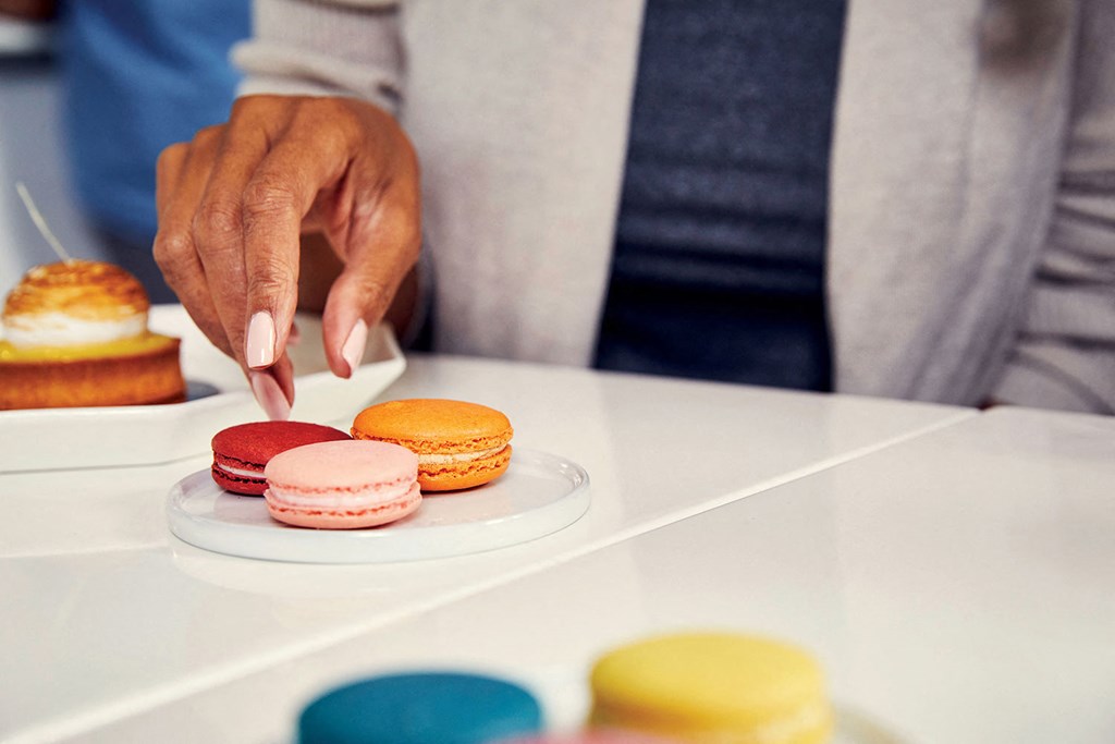 a man selecting a donut from a plate of pastries