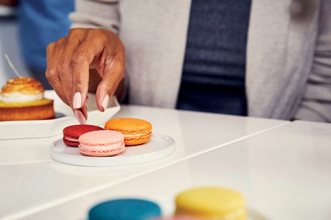 a man selecting a donut from a plate of pastries