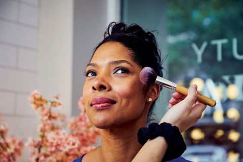 a woman applying makeup with a makeup brush